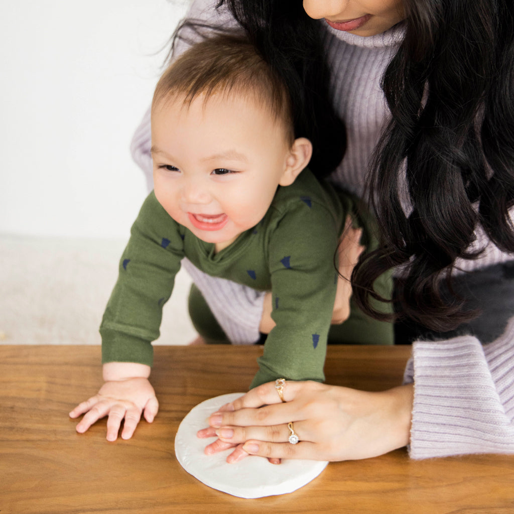 Creating a handprint on the clay keepsake.